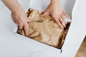 A person packing a white box